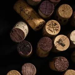 Une collection de bouchons de vin en liège, certains marqués, d'autres usés. Un rappel visuel de la question : vin bouchonné pourquoi.