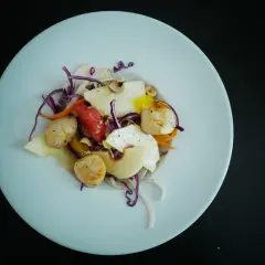 Salade de Saint-Jacques poêlées, avec des fruits et légumes croquants, un délice qui appelle un bon vin blanc.