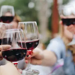 Des verres de vin rouge, peut-être des 4 grand cru classé Saint-Émilion, levés pour un toast.