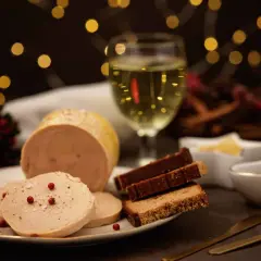 Foie gras tranché, pain d'épices et verre de vin blanc. Quel vin blanc avec le foie gras ? Une ambiance festive avec des lumières douces.