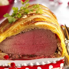 Un magnifique filet mignon en croûte, doré et feuilleté, prêt à être dégusté. Une garniture festive parfaite.