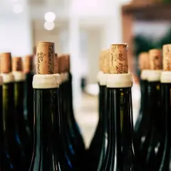 Bouchons en liège sur des bouteilles de vin, certaines indiquant "nom bouteille 15l".