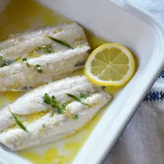 Deux filets de maquereau au four, nappés d'une sauce dorée, ornés de thym et de rondelles de citron. Un plat simple et savoureux.
