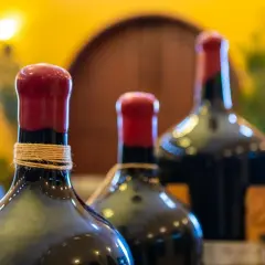 Trois bouteilles de vin, dont une en magnum litres, avec des bouchons rouges et une ficelle autour du col.