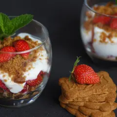 Délicieux tiramisu fraises spéculoos, superposé dans un verre avec des fraises fraîches, de la crème et des miettes de spéculoos.