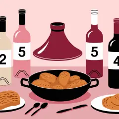 Bouteilles de vin numérotées et un plat de tajine poulet prêt à être dégusté.