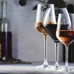 Trois verres de vin, un blanc, un rouge et un rosé, se tiennent sur une table. L'un d'eux, le blanc, semble avoir un goût de vin oxydé.