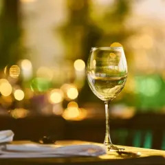 Verre de vin blanc sur une table, ambiance feutrée. La durée conservation vin blanc fermé est une question clé pour apprécier pleinement ses arômes.