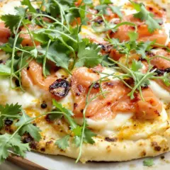 Une délicieuse pizza saumon, garnie de fromage fondant et de coriandre fraîche. Un vrai régal pour les yeux et les papilles !