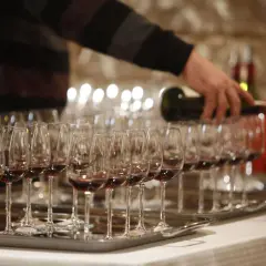 Dégustation de vin rouge, une main verse le liquide dans des verres. Une occasion spéciale pour savourer un premier grand cru.