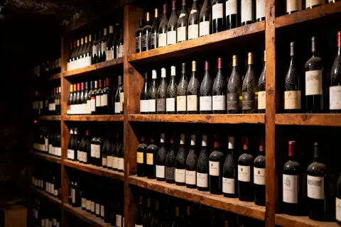 Rayons de cave à vin remplis de bouteilles. La différence entre une cave à vin de service et de vieillissement est subtile, mais la conservation est clé.