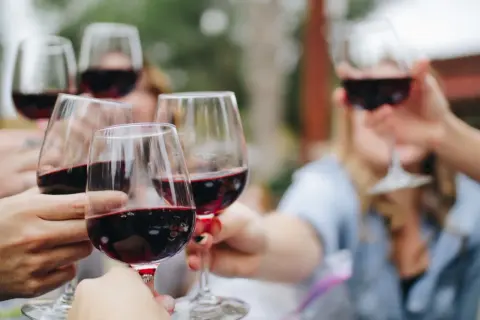Des verres de vin rouge, peut-être des 4 grand cru classé Saint-Émilion, levés pour un toast.