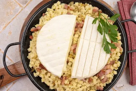 Plat de crozets, lardons et fromage à raclette, prêt à être cuit pour une délicieuse recette croziflette.