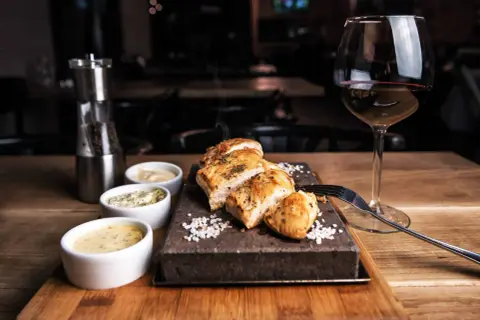 Un plat de viande blanche savoureux, servi avec trois sauces et un verre de vin rouge. La question est : quel vin avec viande blanche ?