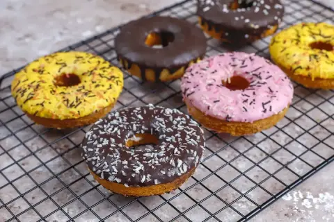 Délicieux donuts colorés, prêts à être dégustés. Une recette facile pour un goûter gourmand.