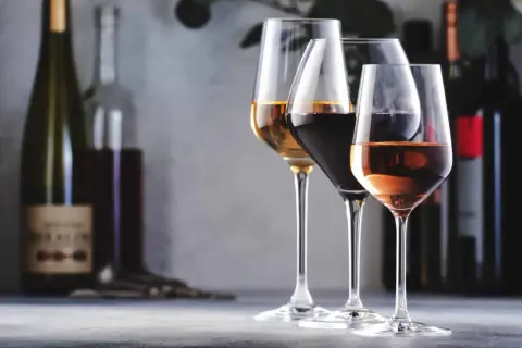 Trois verres de vin, un blanc, un rouge et un rosé, se tiennent sur une table. L'un d'eux, le blanc, semble avoir un goût de vin oxydé.