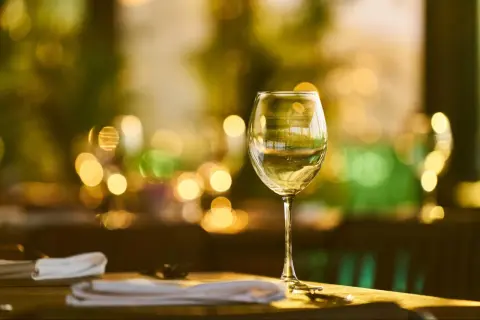 Verre de vin blanc sur une table, ambiance feutrée. La durée conservation vin blanc fermé est une question clé pour apprécier pleinement ses arômes.