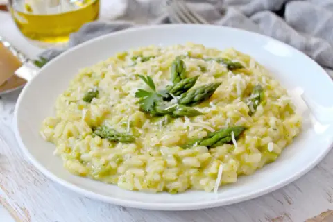 Risotto crémeux aux asperges, garni de parmesan râpé et d'une touche de persil. Un délice qui appelle un bon vin blanc pour risotto.