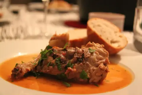 Un plat savoureux d'osso bucco, garni de persil frais, servi avec du pain croustillant. Un délice pour accompagner quel vin avec osso bucco.