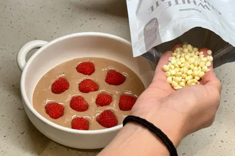 Préparation d'un bowl cake aux framboises, ajout de pépites de chocolat blanc.
