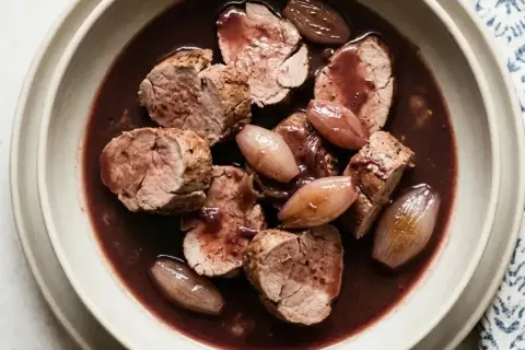 Filet mignon de porc en sauce, servi avec des petits oignons. Quel vin avec filet mignon de porc ? Un Pinot Noir serait parfait.