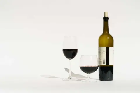 Une bouteille de vin rouge et deux verres remplis. Combien de verres dans une bouteille de vin ? La réponse est dans la dégustation.