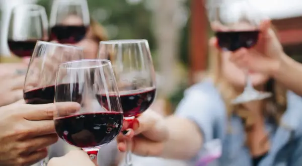 Des verres de vin rouge, peut-être des 4 grand cru classé Saint-Émilion, levés pour un toast.