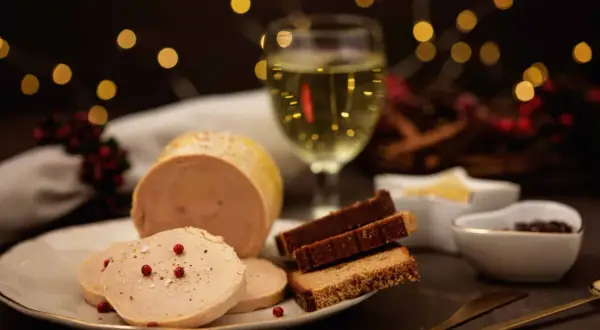 Foie gras tranché, pain d'épices et verre de vin blanc. Quel vin blanc avec le foie gras ? Une ambiance festive avec des lumières douces.