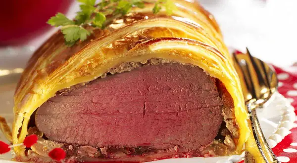 Un magnifique filet mignon en croûte, doré et feuilleté, prêt à être dégusté. Une garniture festive parfaite.