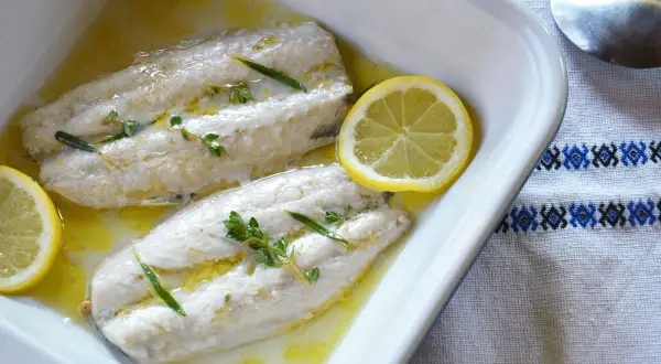 Deux filets de maquereau au four, nappés d'une sauce dorée, ornés de thym et de rondelles de citron. Un plat simple et savoureux.