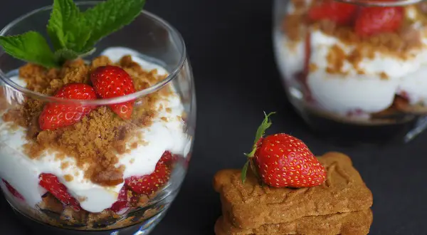 Délicieux tiramisu fraises spéculoos, superposé dans un verre avec des fraises fraîches, de la crème et des miettes de spéculoos.