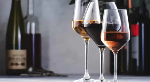 Trois verres de vin, un blanc, un rouge et un rosé, se tiennent sur une table. L'un d'eux, le blanc, semble avoir un goût de vin oxydé.