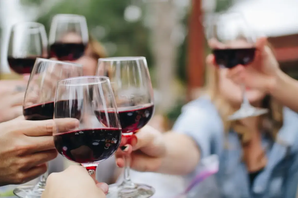Des verres de vin rouge, peut-être des 4 grand cru classé Saint-Émilion, levés pour un toast.