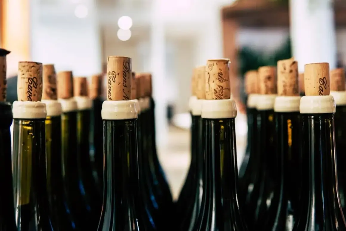 Bouchons en liège sur des bouteilles de vin, certaines indiquant "nom bouteille 15l".