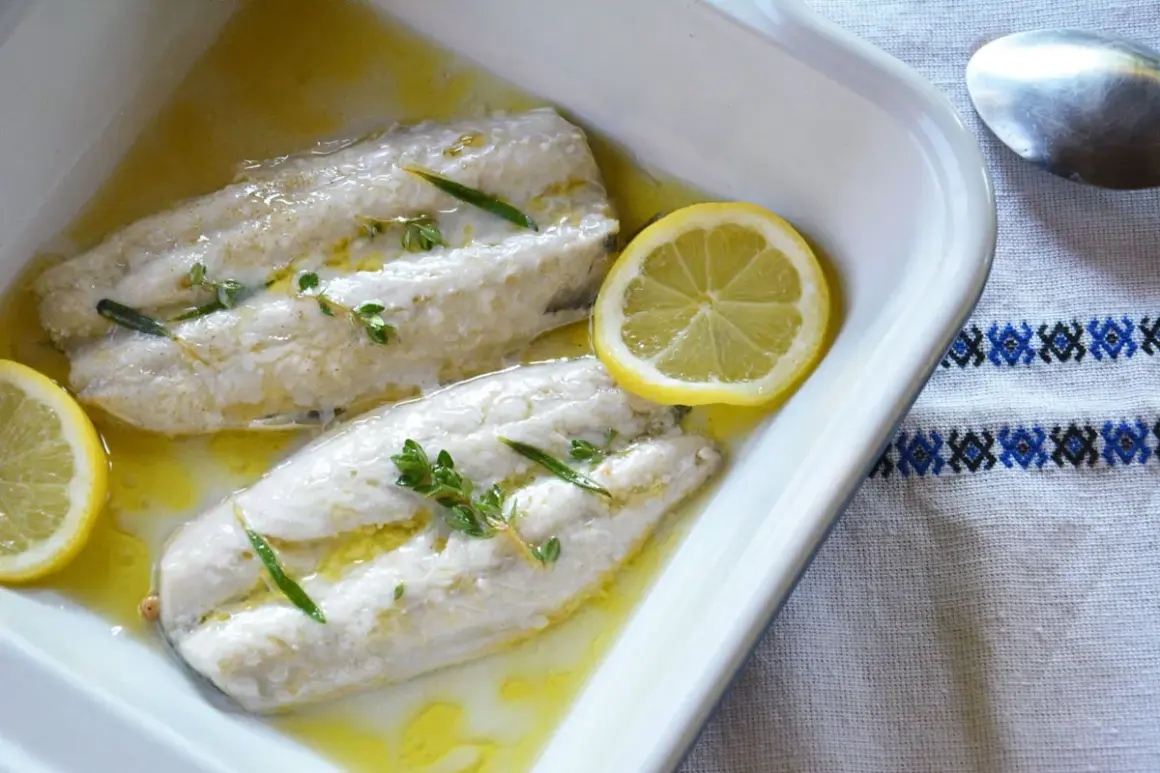 Deux filets de maquereau au four, nappés d'une sauce dorée, ornés de thym et de rondelles de citron. Un plat simple et savoureux.