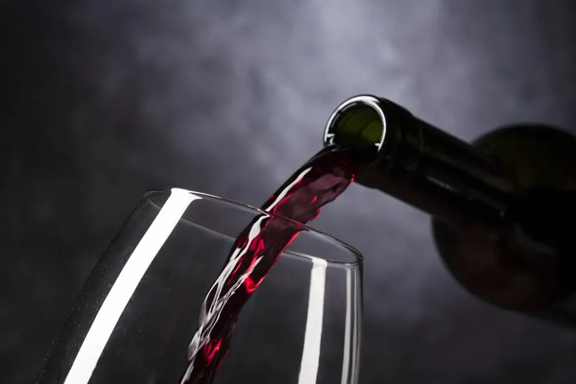 Un vin rouge est versé dans un verre. Parfait pour accompagner un poulet basquaise.