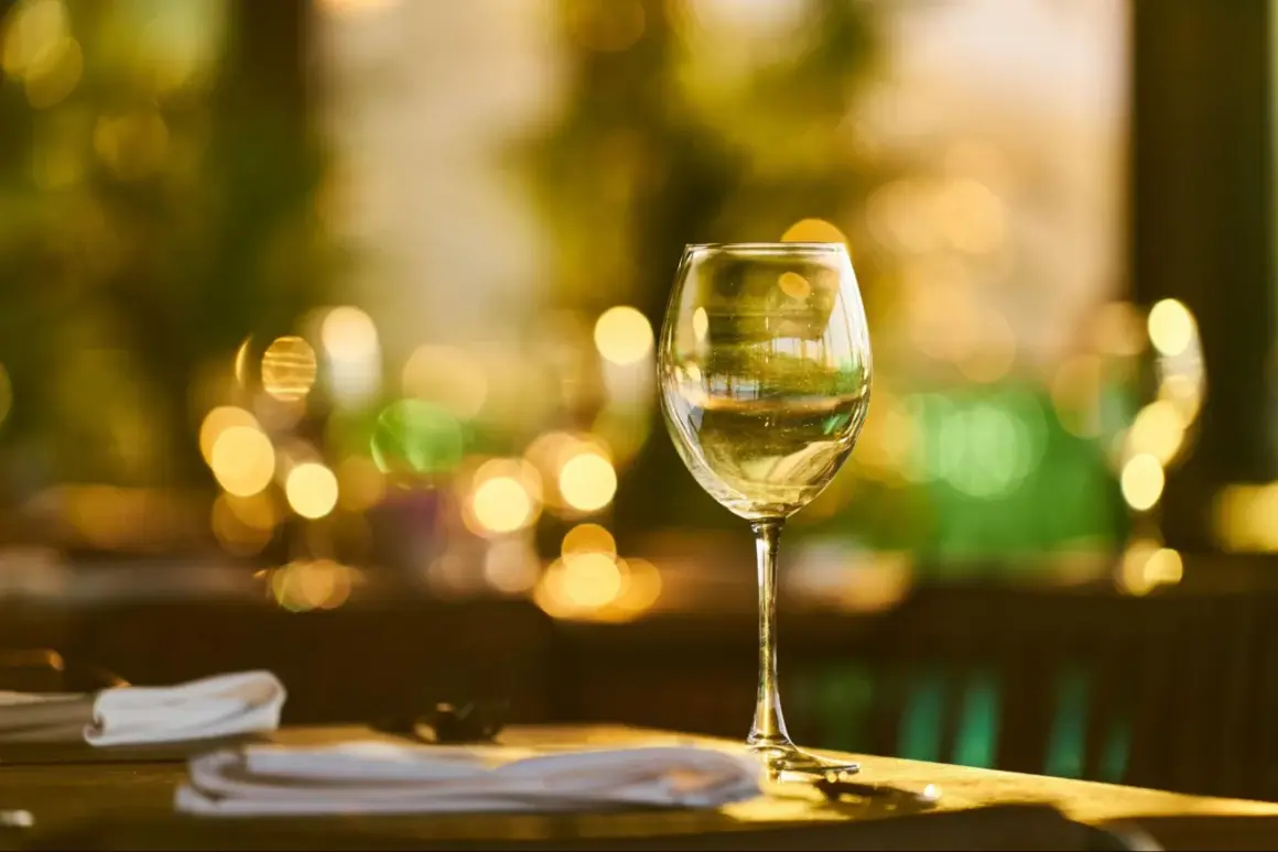 Verre de vin blanc sur une table, ambiance feutrée. La durée conservation vin blanc fermé est une question clé pour apprécier pleinement ses arômes.