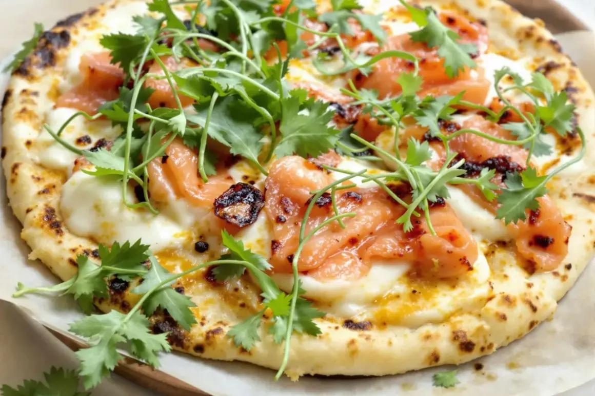 Une délicieuse pizza saumon, garnie de fromage fondant et de coriandre fraîche. Un vrai régal pour les yeux et les papilles !