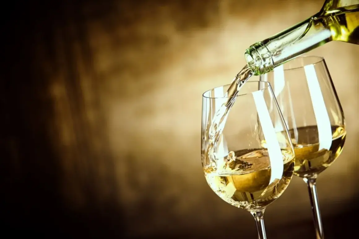 Un vin blanc sucré est versé dans un verre, créant une ambiance chaleureuse et invitante.
