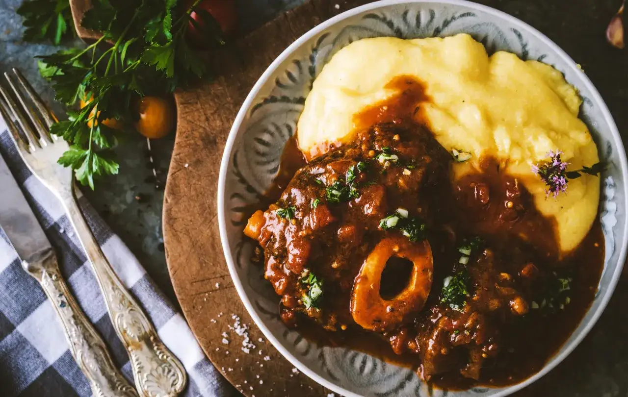 Un plat d'osso bucco savoureux servi avec de la polenta crémeuse. Le choix idéal pour savoir quel vin avec osso bucco.
