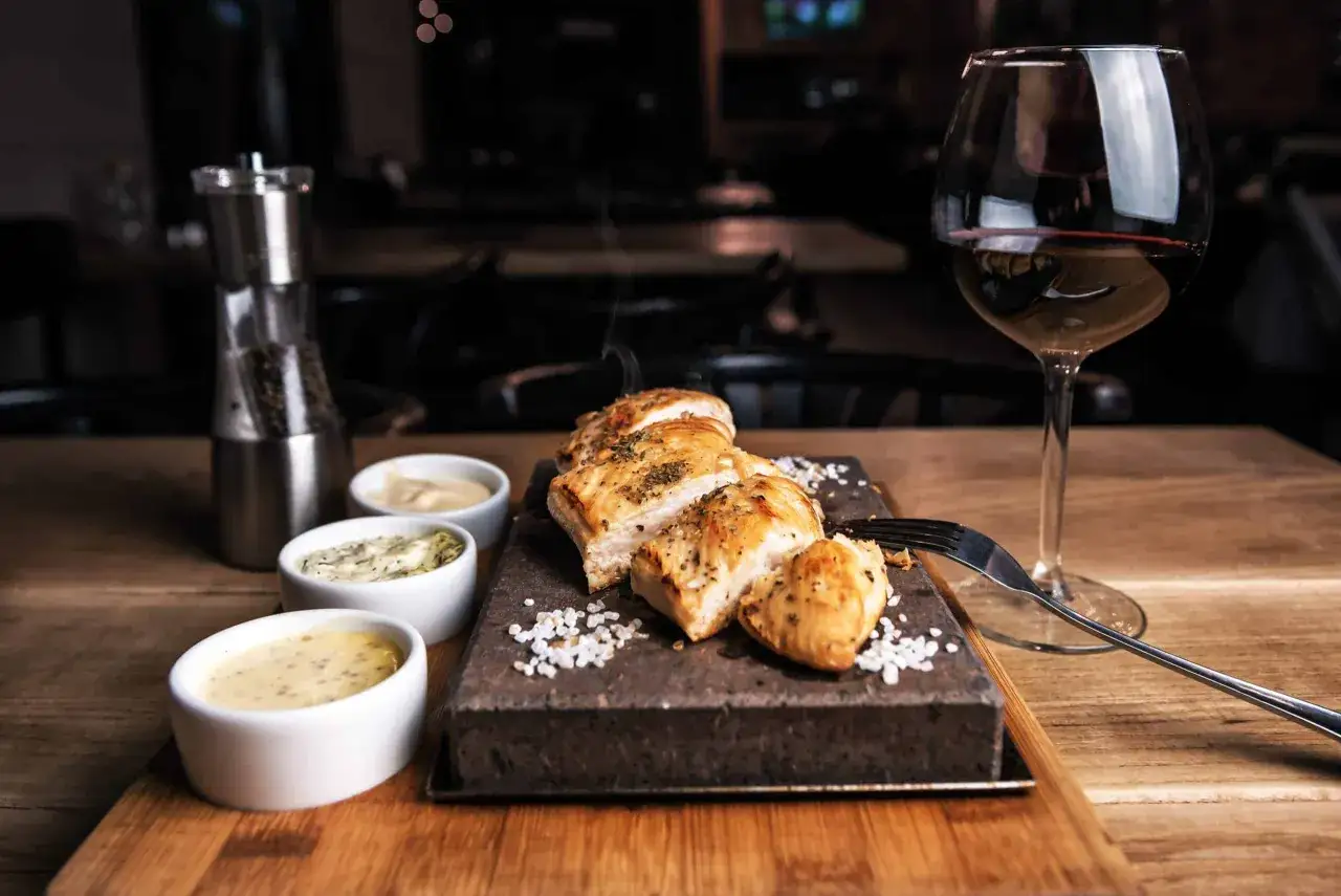 Un plat de viande blanche savoureux, servi avec trois sauces et un verre de vin rouge. Id&eacute;al pour savoir quel vin avec viande blanche.