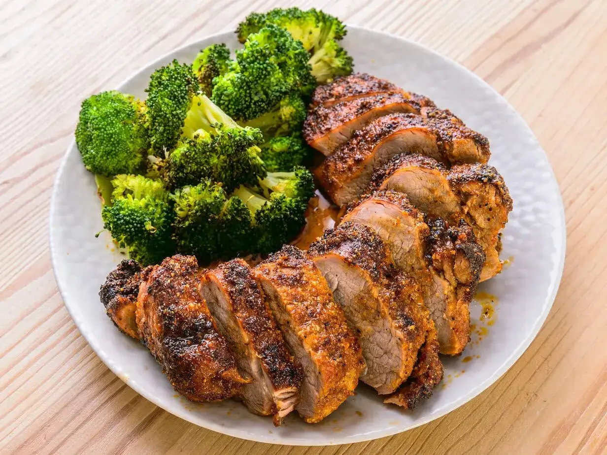 Filet mignon air fryer, tranch&eacute; et servi avec du brocoli r&ocirc;ti. Un repas sain et savoureux.