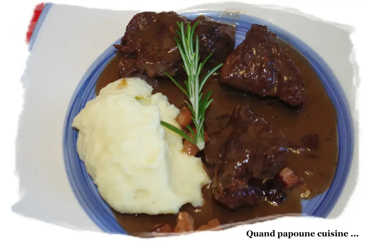 Un plat de sanglier en sauce, servi avec une purée onctueuse et une branche de romarin. Un délice qui invite à se demander quel vin avec sanglier en sauce serait parfait.