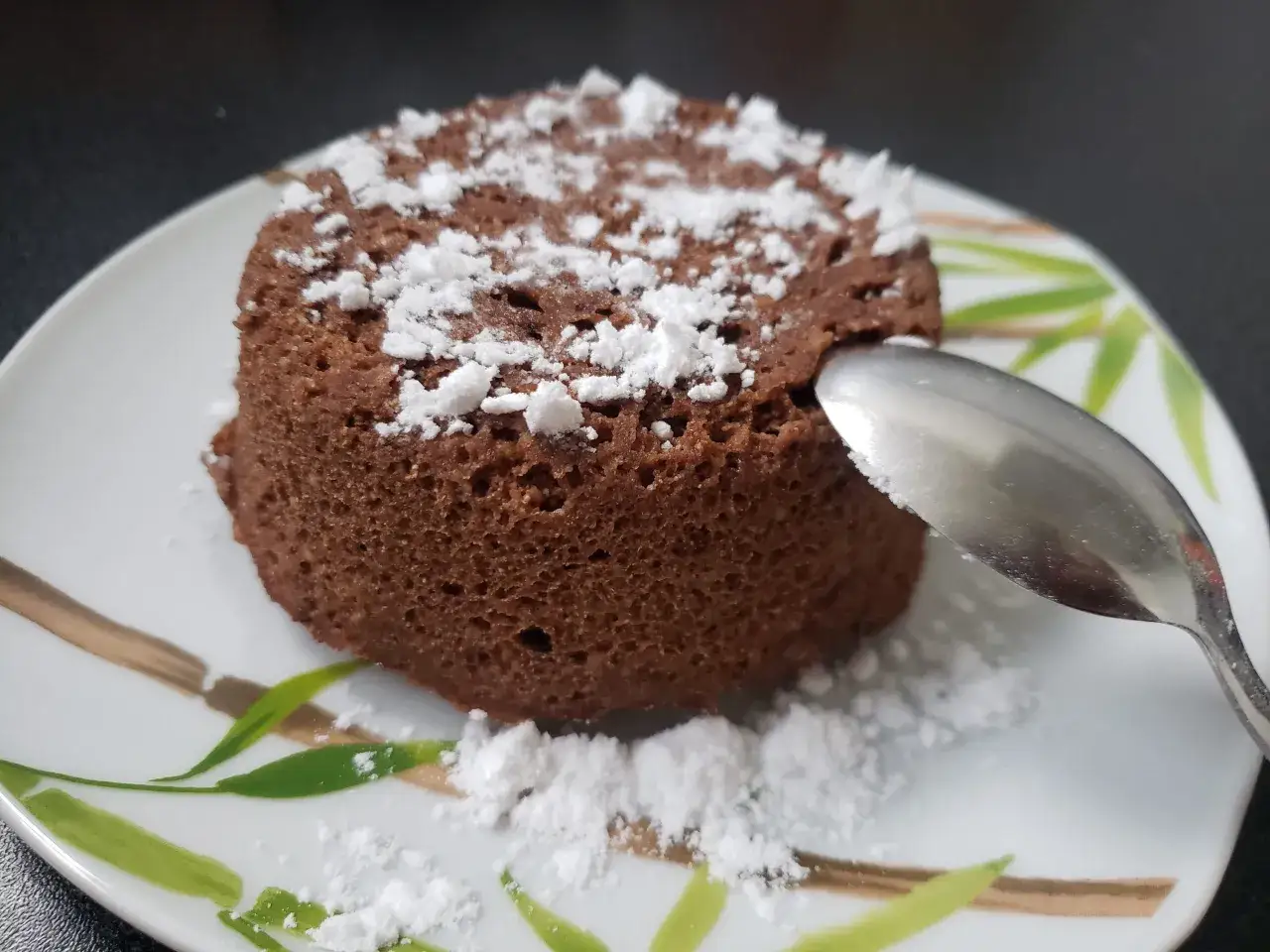 Un d&eacute;licieux bowl cake au chocolat, saupoudr&eacute; de sucre glace, pr&ecirc;t &agrave; &ecirc;tre d&eacute;gust&eacute; avec une cuill&egrave;re.