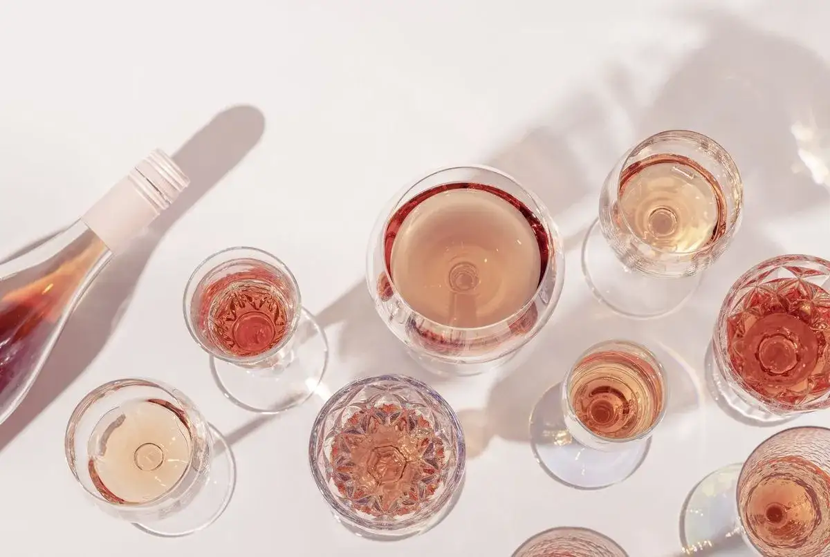 Verre de vin rosé, une bouteille et plusieurs verres remplis de vin rosé. Idéal pour savoir que faire avec un mauvais vin rosé.