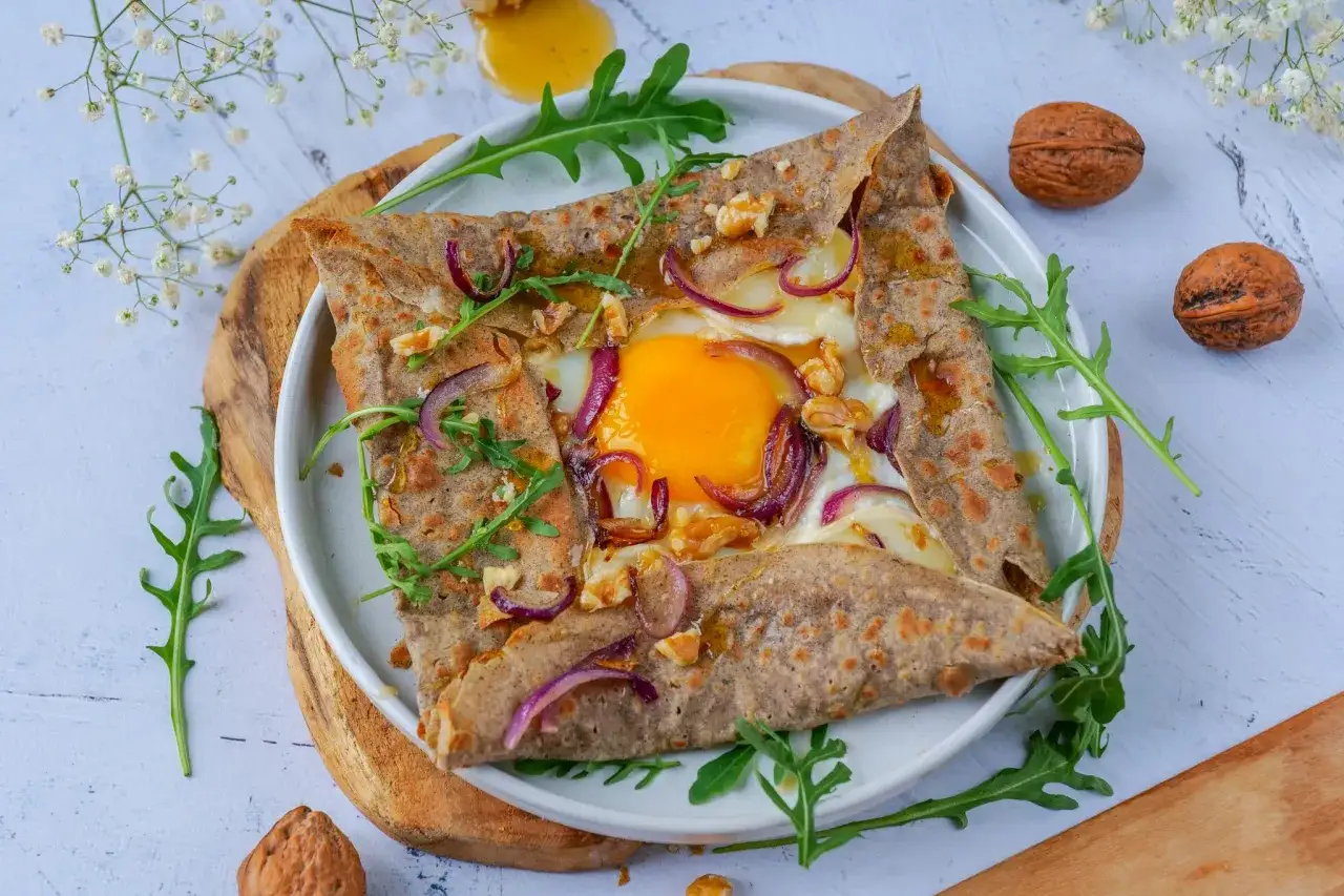 D&eacute;licieuse galette sarrasin garnie d'un &oelig;uf coulant, oignons rouges, noix et roquette. Un d&eacute;lice pour les papilles !