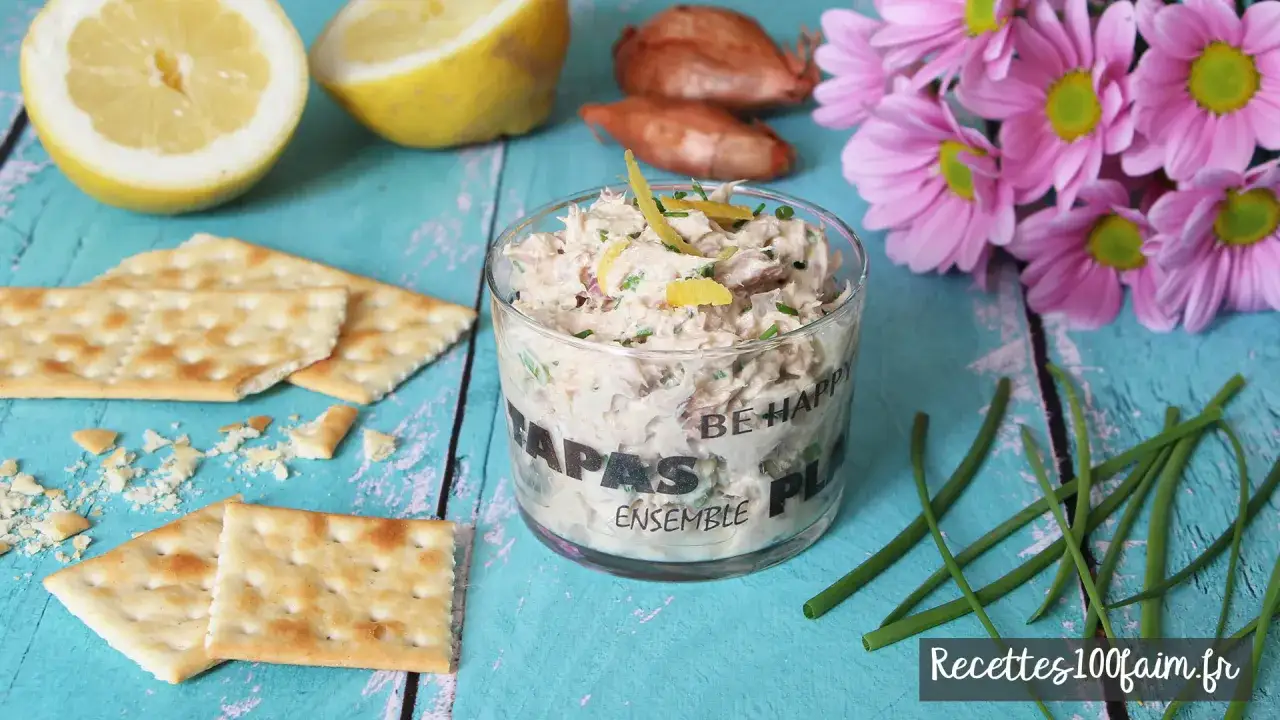 Un délicieux pot de rillettes de thon, garni de zestes de citron, est prêt à être dégusté avec des crackers.