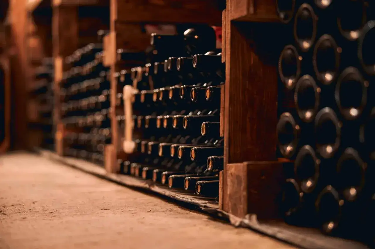 Cave à vin sombre remplie de bouteilles. Un vin qui peut se garder 20 ans attend patiemment son heure.