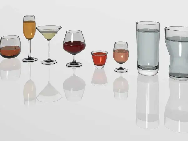Diversité de verres à vin et à eau, prêts pour un repas au restaurant. Chaque verre présente une quantité différente de liquide.