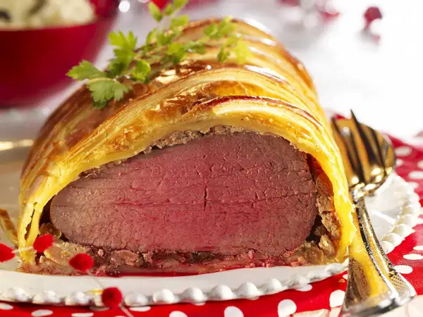 Un magnifique filet mignon en croûte, doré et feuilleté, prêt à être dégusté. Une garniture festive parfaite.